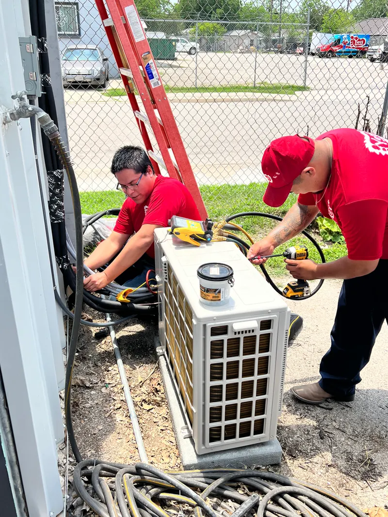 Two Yeti Cooling & Heating technicians installing a ductless mini-split condenser